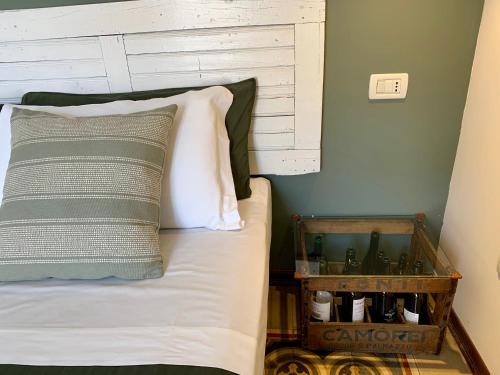 a bed with a headboard and a table with bottles on it at Porta Ronca - B&B, Suites & Apts in Rho
