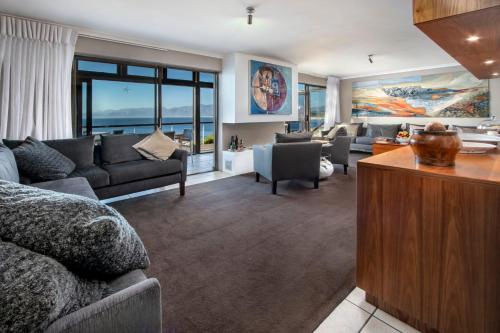 a living room with couches and a living room with a view at Cliff Lodge in Gansbaai
