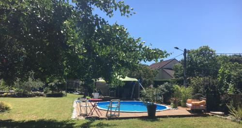 - une piscine dans une cour avec un arbre dans l'établissement APPART D'HOTES BRIVE OUEST (USSAC), à Ussac