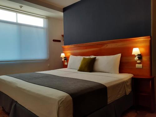 a bedroom with a large bed with a window at Casa D´Cristhi in Puerto Baquerizo Moreno