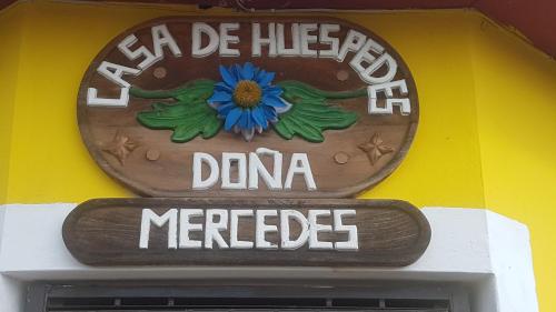 una señal en el lado de un edificio con una flor azul en Hostal Doña Mercedes, en Juayúa