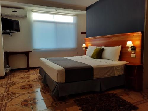 a bedroom with a large bed with a window at Casa D´Cristhi in Puerto Baquerizo Moreno