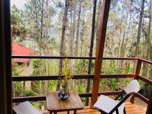 - Balcón con mesa y sillas y vistas al bosque en Casa de Arbol, Rancho Tierra Alta en Jarabacoa