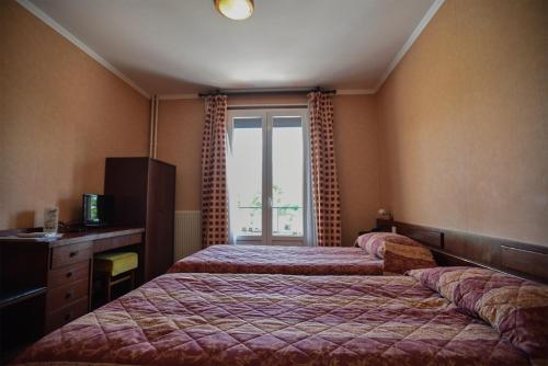 a hotel room with two beds and a window at le Santa Maria in Santa-Maria-Siché