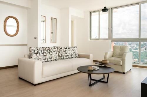 a living room with a white couch and a table at Enchanting City View Apartment - PH Quartier Del Mar in Panama City
