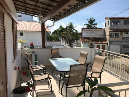 een patio met een tafel en stoelen op een balkon bij Casa Rosemary in Lauro de Freitas