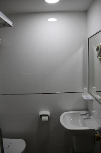 a bathroom with a sink and a toilet and a mirror at Hostal Maribel in Almería