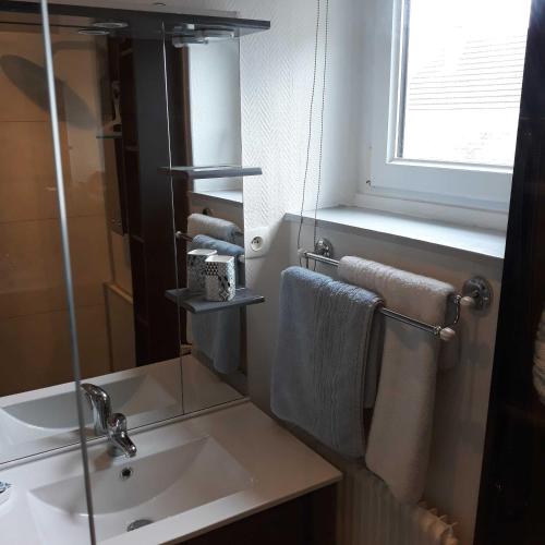 a bathroom with a sink and a window and towels at L'HORIZON Vue mer et falaises in Fécamp