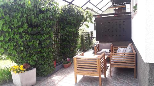 a patio with two chairs and a table and a hedge at Snežak (Snowman) in Bohinj