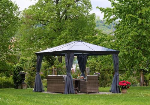a gazebo with a table and chairs in a yard at Le Jardin des Roses - parking gratuit dans la rue - gare à 500 m in Saverne