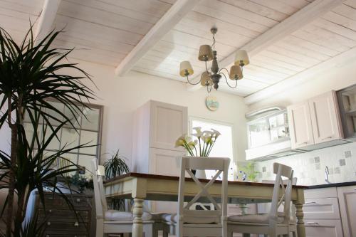 a kitchen with white cabinets and a table and chairs at Azzurro B&B in Cefalù