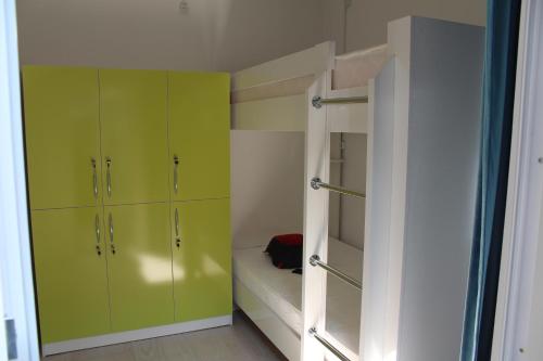 a small room with green cabinets and a bunk bed at Park Hostel Osh in Osh