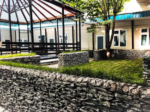 a stone retaining wall in front of a building at Park Hostel Osh in Osh