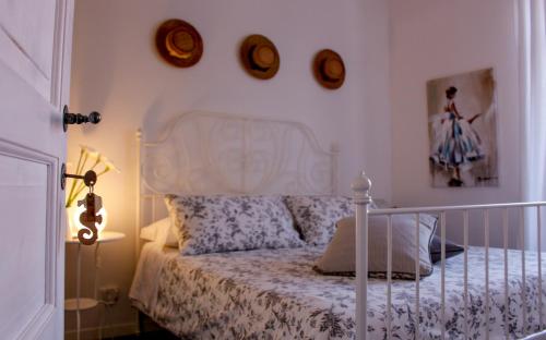 a bedroom with a white bed with pillows and clocks on the wall at Azzurro B&B in Cefalù