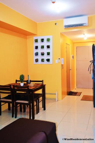 a dining room with yellow walls and a table and chairs at Wind Residences For Rent - Luiice in Tagaytay