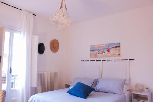 a bedroom with a bed with blue pillows at Azzurro B&B in Cefalù