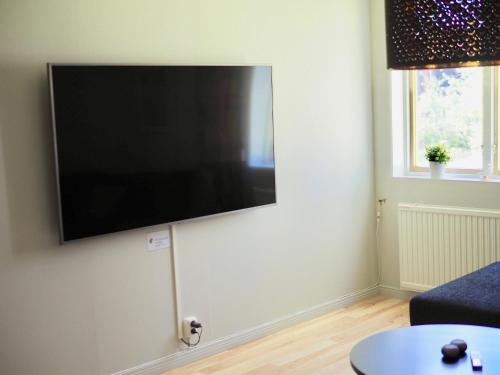 Una sala de estar con un televisor de pantalla plana en una pared. en Orsastuguthyrning-Born, en Orsa