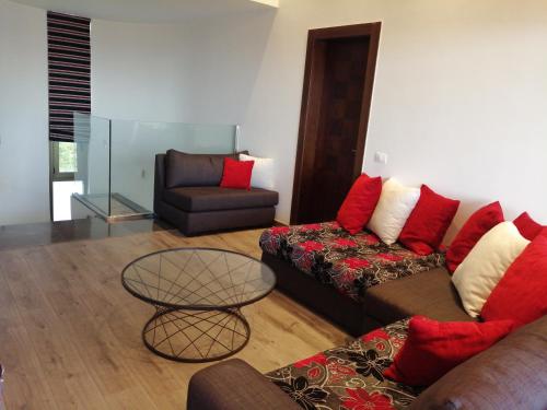 a living room with a couch and a chair at LES Dunes De Faqra ( c duplex ) in Abū Mīzān
