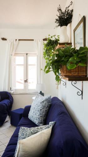 a living room with a blue couch and a window at Azzurro B&B in Cefalù