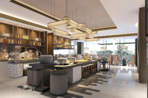 a kitchen with chefs preparing food in a restaurant at Radisson Lampung Kedaton in Bandar Lampung
