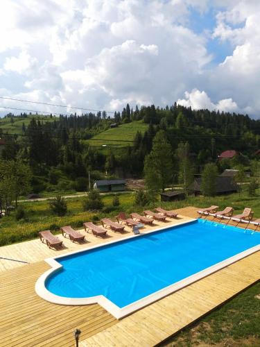 a large swimming pool with chairs and umbrellas at Plavianska Sadyba in Plav'ya
