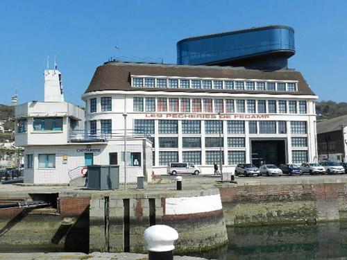 a large white building with cars parked in front of it at L'HORIZON Vue mer et falaises in Fécamp