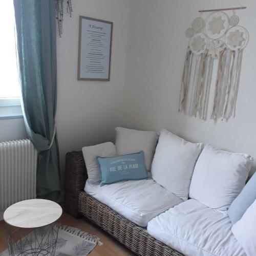 a living room with a couch and a table at L'HORIZON Vue mer et falaises in Fécamp