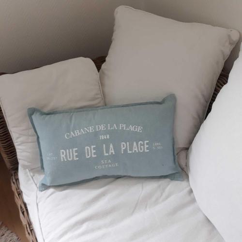 a blue pillow sitting on top of a bed at L'HORIZON Vue mer et falaises in Fécamp