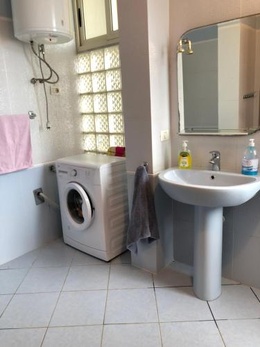 a bathroom with a washing machine and a sink at Beach View! Seaside Apartment in Durrës