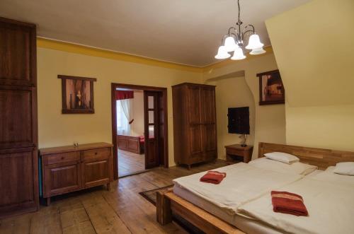 a bedroom with two beds and a television in it at Pension Pod Radnicí in Český Krumlov