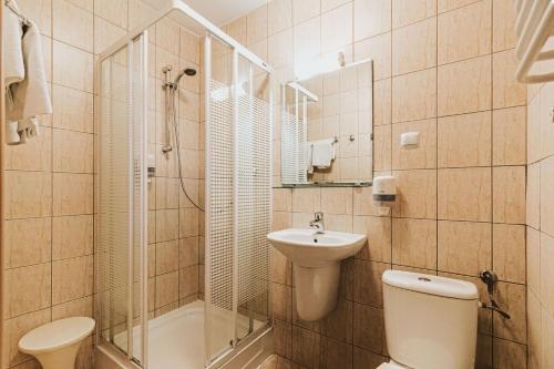a bathroom with a toilet and a sink and a shower at Hotel Gromada Łomża in Łomża