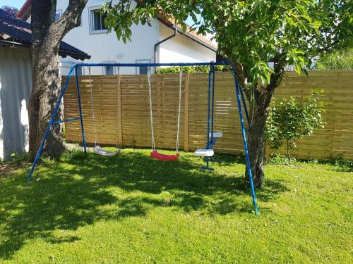 a swing set in a yard next to a tree at Bogi's Ferienhaus - Pension in Laakirchen
