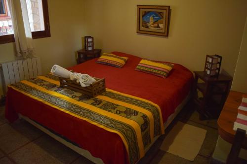a bedroom with two beds with red sheets and avertisement at Azul Humahuaca Hostal in Humahuaca