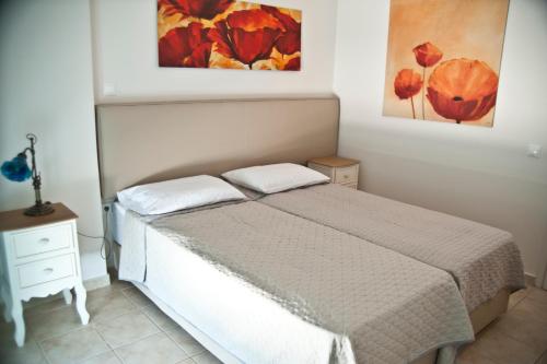 a bedroom with a bed and a painting on the wall at Chalkida Apartments in Chalkida