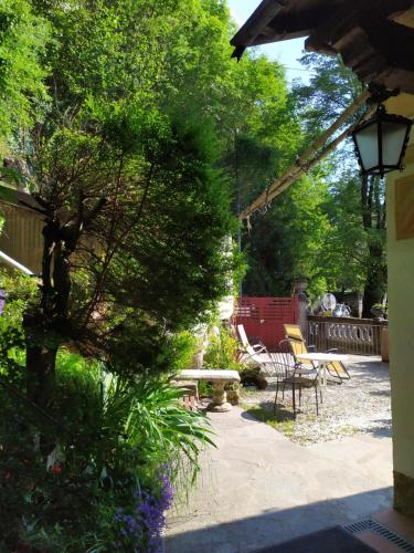 a garden with a bench and a table and chairs at B&B Il Balcone sul Lago in Brunate