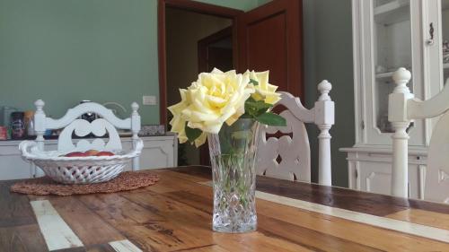 a vase of yellow flowers on a wooden table at Villa dei Pescatori in LʼAquila