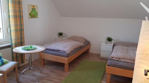 Kleines Zimmer mit einem Bett und einem Tisch in der Unterkunft Apartments Bottrop in Bottrop-Kirchhellen