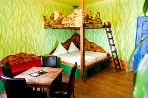 a room with a bunk bed with a table and a tableablish at Gästehaus Mezcalero in Dresden