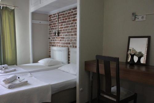 a room with two beds and a chair and a mirror at Macide Hanım Konağı in Ayvalık