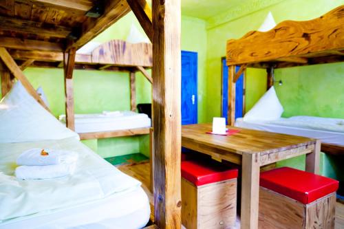 a room with two bunk beds and a wooden table at Gästehaus Mezcalero in Dresden