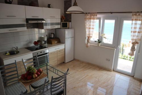a kitchen with a table with a bowl of fruit on it at Apartments Mrdan in Seget Vranjica