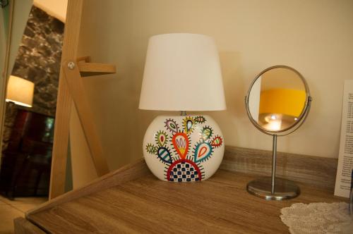 a lamp sitting on a table next to a mirror at B&B La Villa in Giardini Naxos