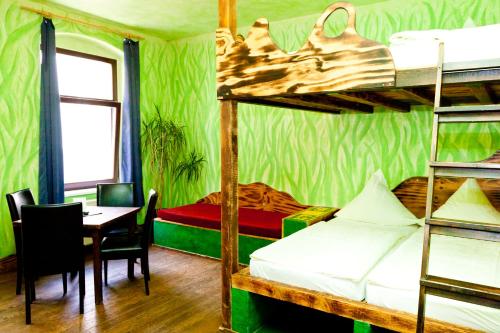 a room with two bunk beds with a table and a dining room at Gästehaus Mezcalero in Dresden