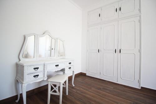 a white dressing table with a mirror and a stool at White Bride FZ in Fuzeta
