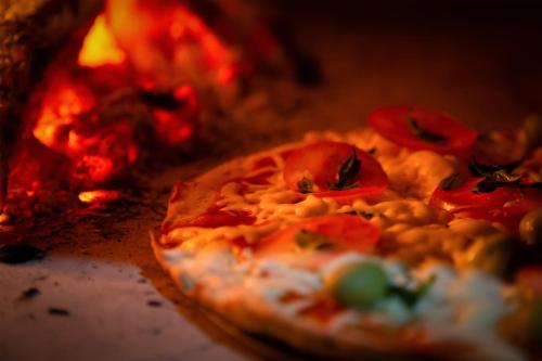 a pizza is sitting in a fire oven at Pousada Lua Luana in Cambuquira