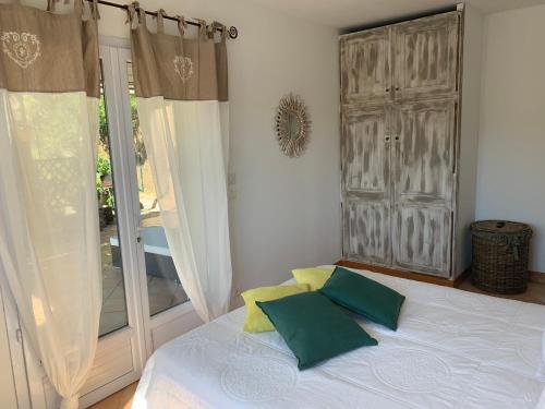 a bedroom with a bed with two pillows and a window at Villa Pampasgiolu in Tizzano