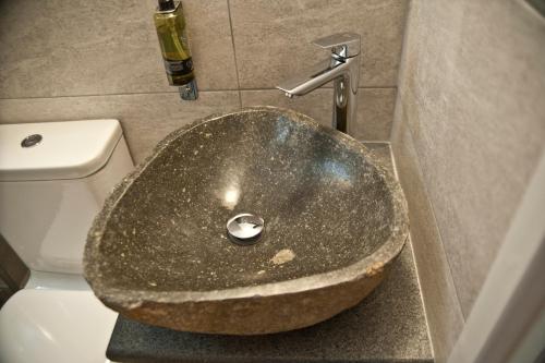 a bathroom with a stone sink in front of a toilet at Chalkida Apartments in Chalkida