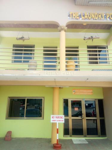 a yellow building with a sign in front of it at Feehi's Place in Accra