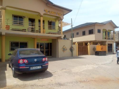 a blue car parked in front of a building at Feehi's Place in Accra