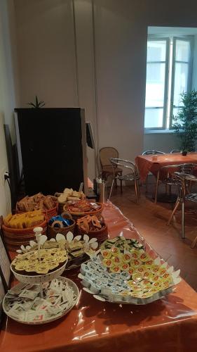 a table with many plates of food on it at Ospitalia del Mare Hostel in Levanto
